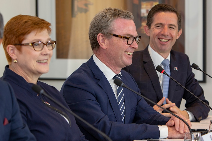 Payne, Pyne abd Birmingham sit in a row at a desk, all smiling.