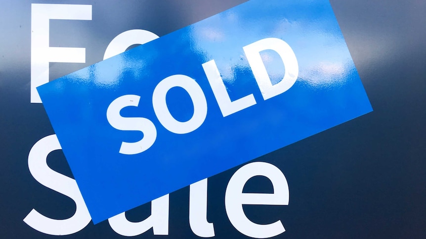 A sold sticker on a real estate for sale sign.