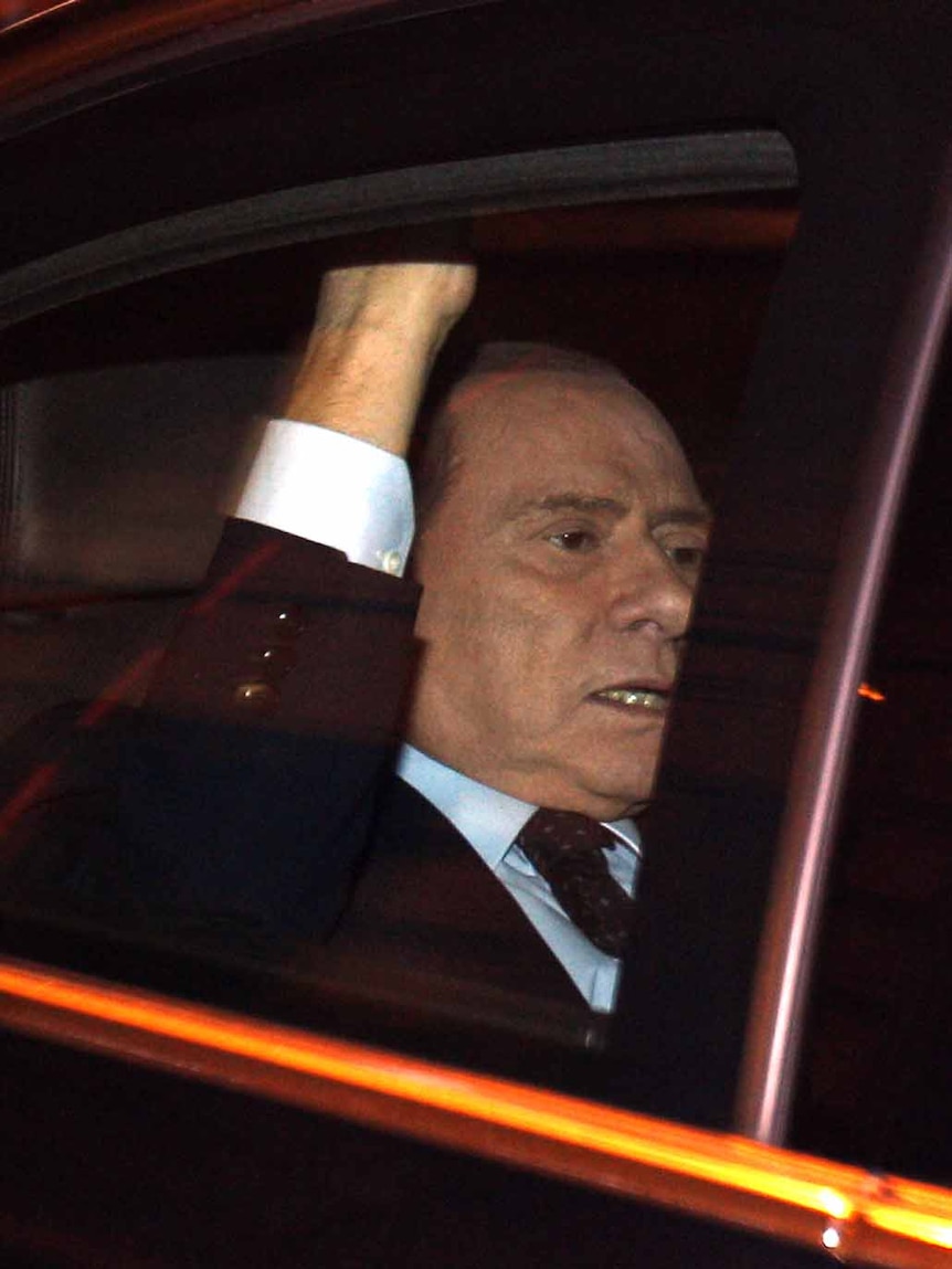 End of an era: Silvio Berlusconi leaves parliament after the vote.