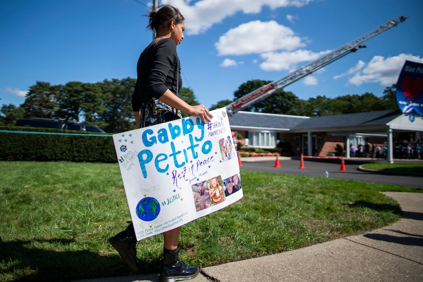A woman carries a placard in honour of Gabby Petito