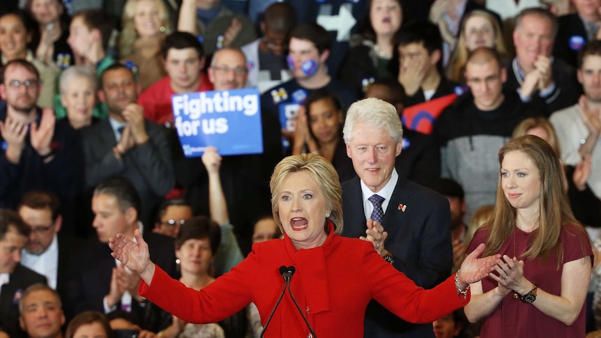 Democratic presidential candidate former Secretary of State Hillary Clinton speaks to supporters as Former President Bill Clinton and daughter Chelsea Clinton look on during her caucus night event in the Olmsted Centre