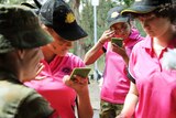 Schoolgirls apply army face paint