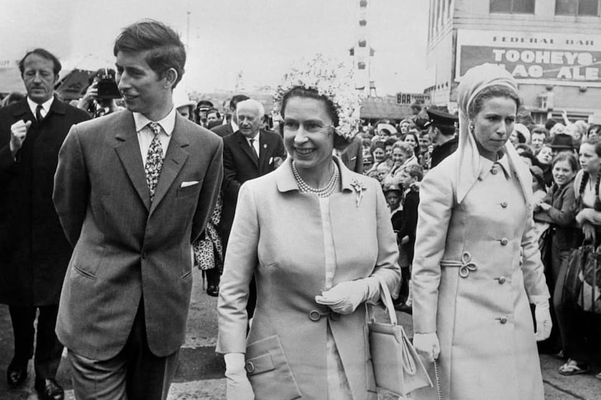 Prince Charles wearing a suit and tie stands on far left next to Princess royal