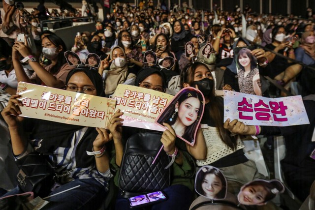 Three women holds signs that reads in Korean.
