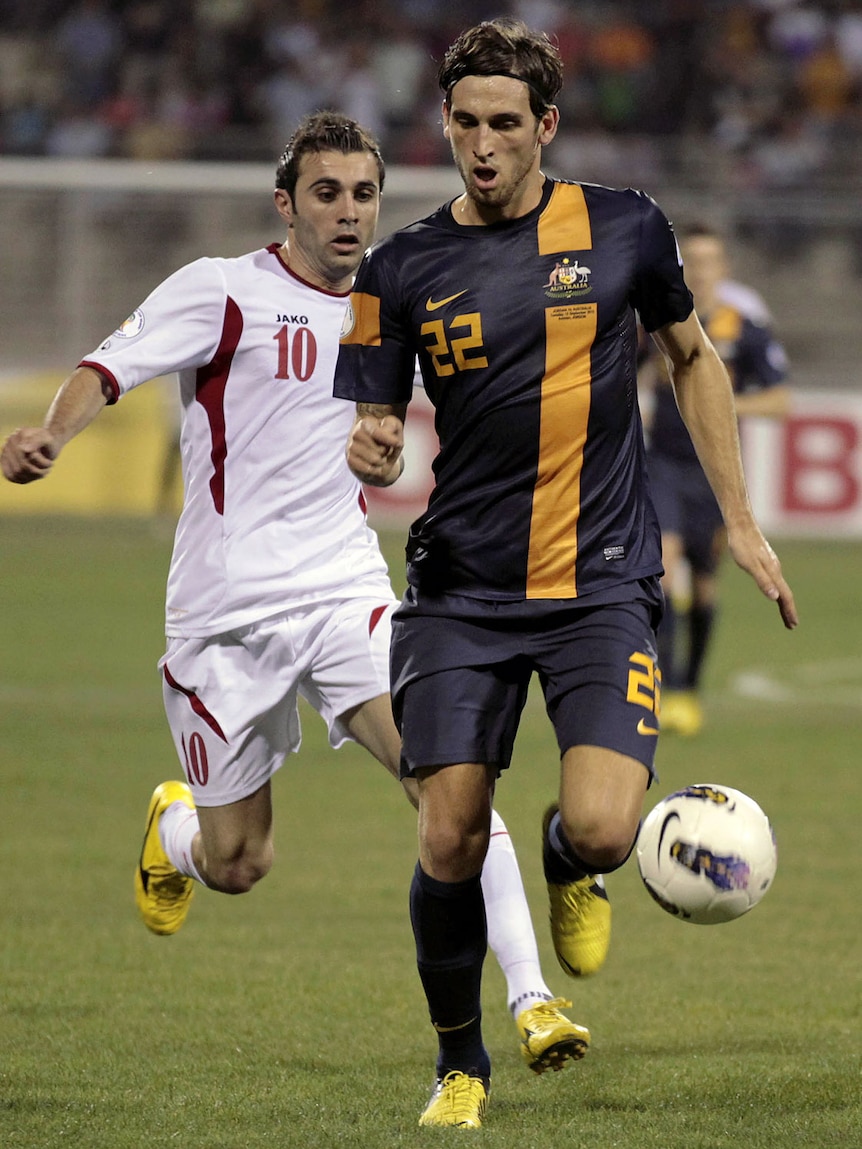 Jordan forward Ahmed Hayel challenges Socceroos defender Matthew Spiranovic.