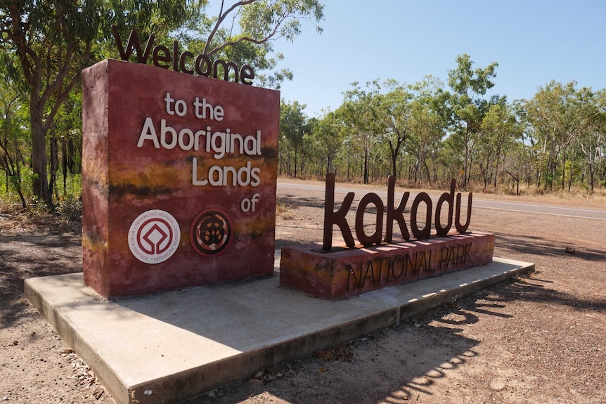 A sign reading 'Welcome to the Aboriginal Lands of Kakadu National Park' at the start of the park.