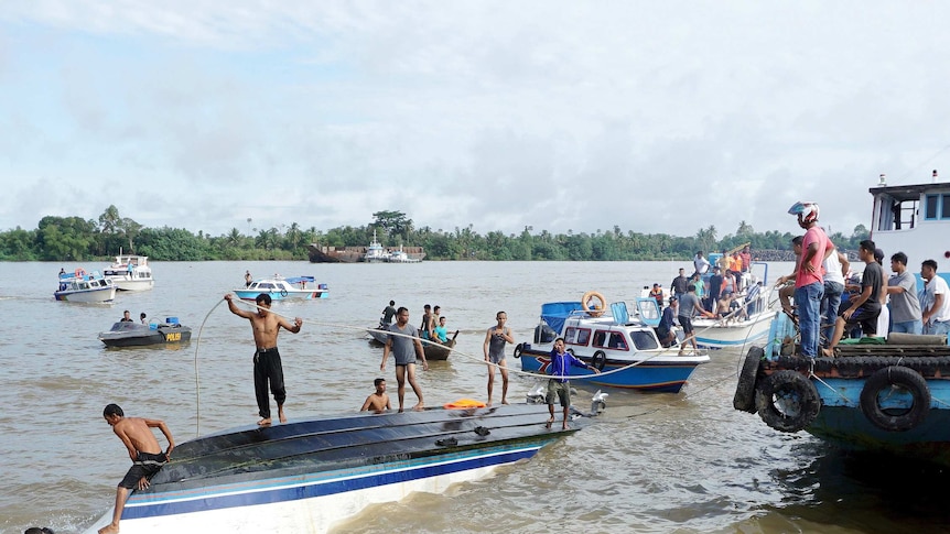 An Indonesia rescue team searches for victims of a boat that capsized off Indonesia's Kalimantan island