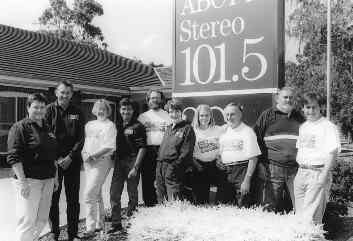 black and white photo of group standing in front of ABC Gippsland building in 1995