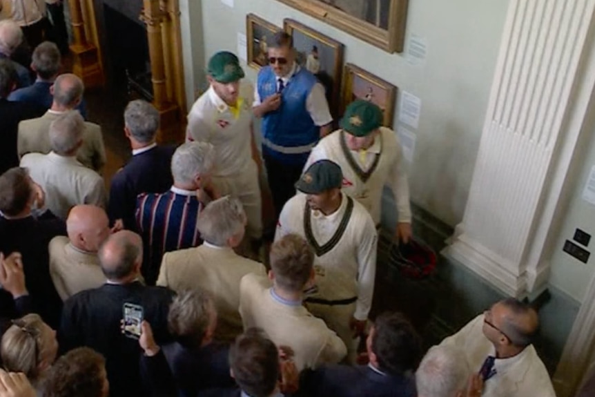 A screenshot showing Australian cricketers walking through the Lord's Long Room, with Usman Khawaja talking to a member.