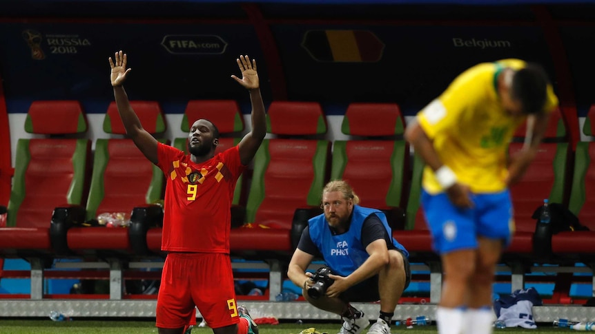 Romelu Lukaku on his knees celebrating Belgium's win over Brazil