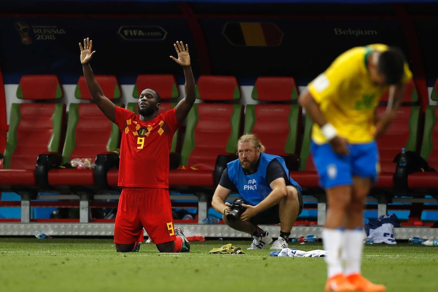 Romelu Lukaku on his knees celebrating Belgium's win over Brazil