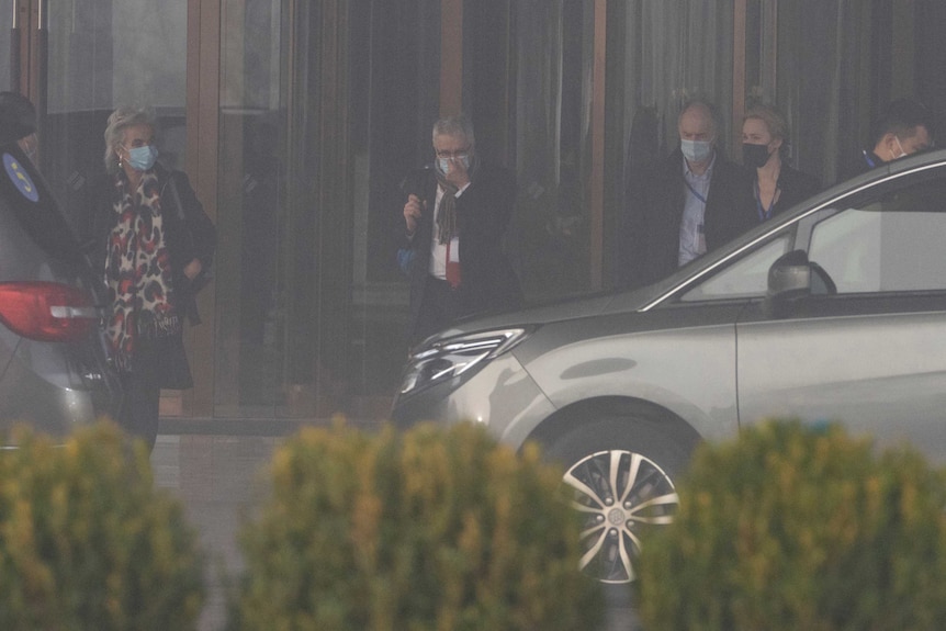 Members of a World Health Organization team leave their hotel on a foggy day for another day of field visit