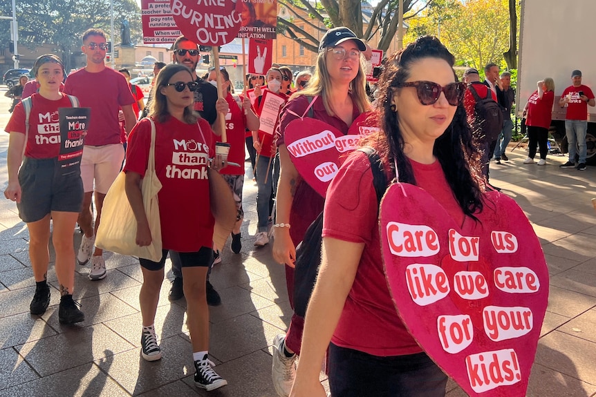 Women wearing red t-shirts and signs around thir necks