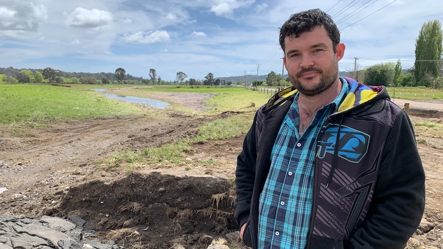 A man standing next to a hole.