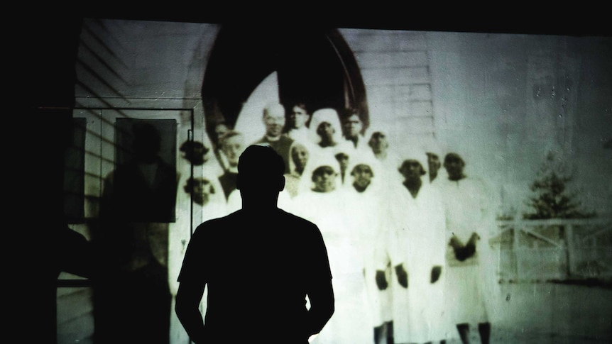 A silhouette of actor Ian Michael on stage during a performance of HART.