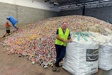 Reef Recycling operations manager Shane Stratton standing in front of a huge pile of aluminium cans.