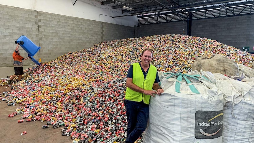 Reef Recycling operations manager Shane Stratton standing in front of a huge pile of aluminium cans.