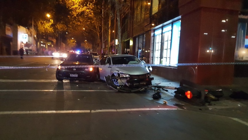 A damaged car in Melbourne's CBD with police tape around it.