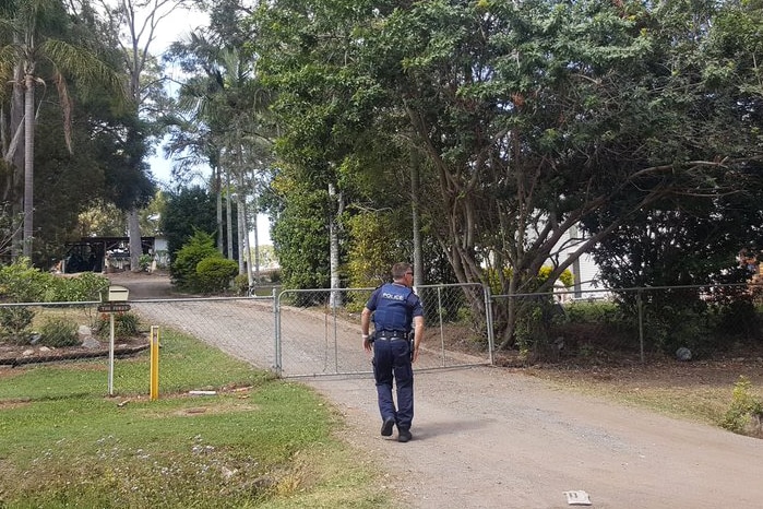 Police officers walks into the property on Teesdale Road at Alexandra Hills.