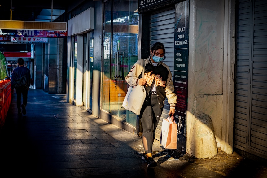 a woman in a mask shopping on a sydney street