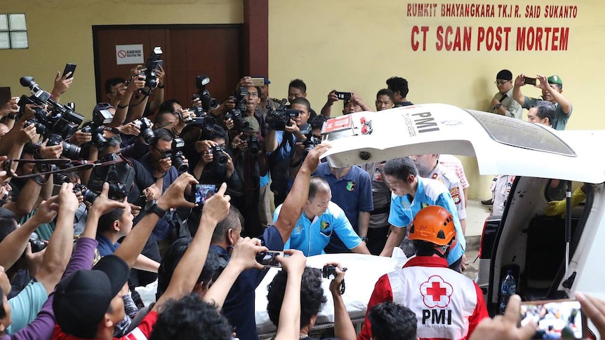 People with camera trying to capture a body bag out from an ambulance