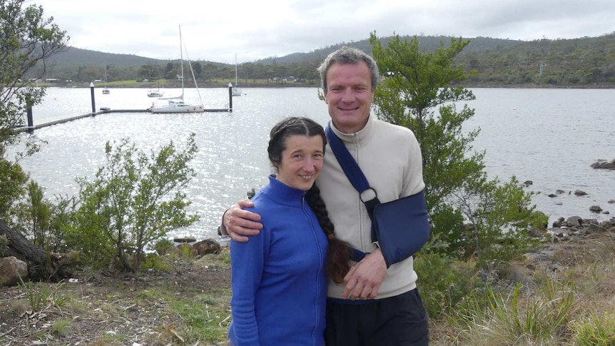 Sailors Carina Juhhova and Christophe Mora stand in front of their yacht L'Envol at Murdunna, Tasmania.