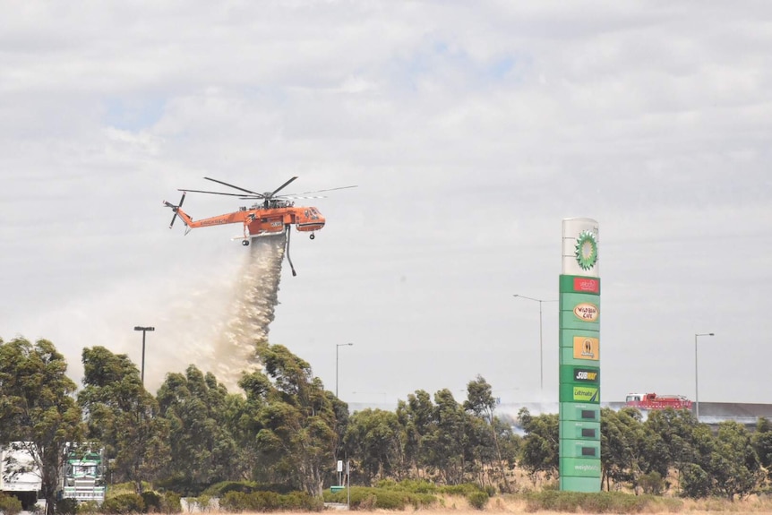 Air crane dropping retardent near petrol station