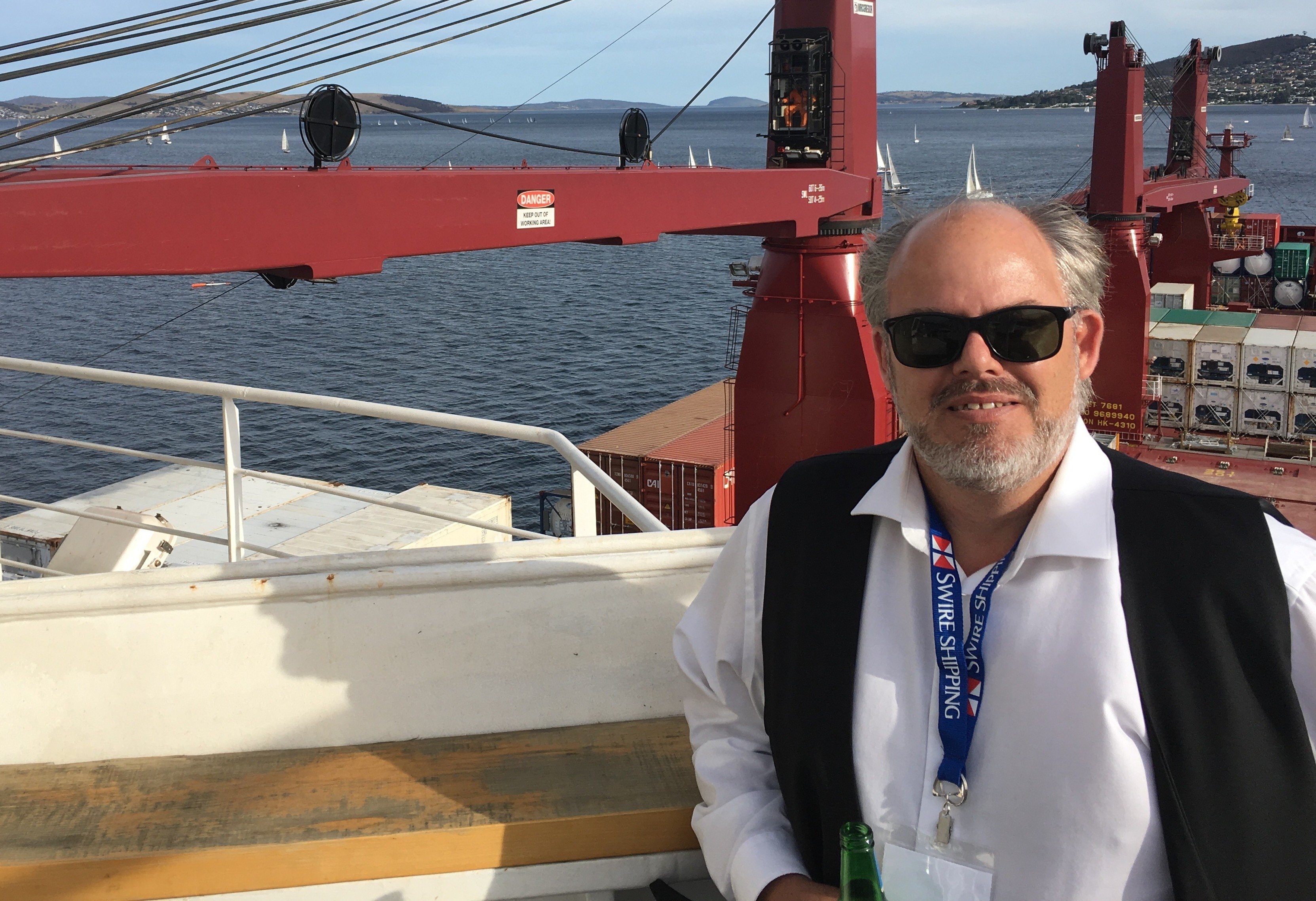 Un hombre se encuentra en un gran buque portacontenedores.