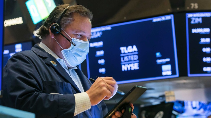 A man uses a tablet device on the floor of the New York Stock Exchange.