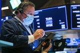 A man uses an tablet device on the floor of the New York Stock Exchange.