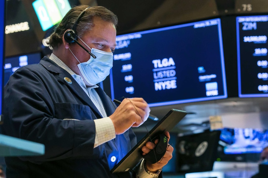 A man uses an tablet device on the floor of the New York Stock Exchange.