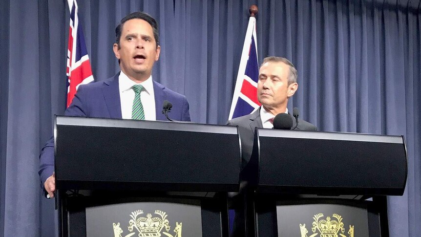 Treasurer Ben Wyatt and Health Minister Roger Cook standing at lecturn answering questions.