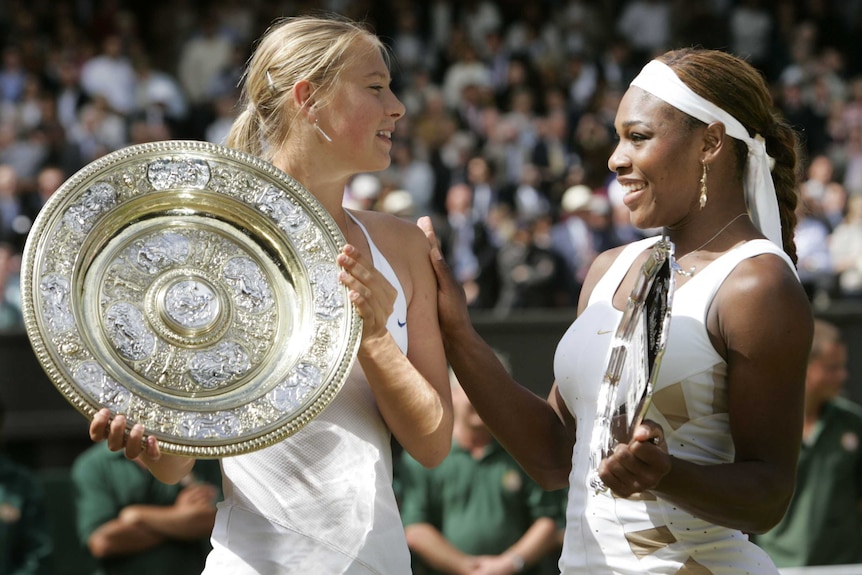 Maria Sharapova with the 2004 Wimbledon trophy alongside Serena Williams