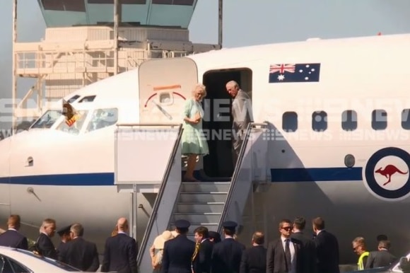 Two people standing on the steps of a plane.