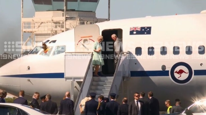 Two people standing on the steps of a plane.