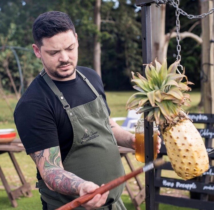 Man standing at a roasting pit