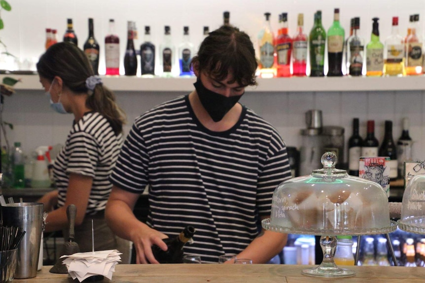 Cafe workers wear masks as they prepare food and drinks.