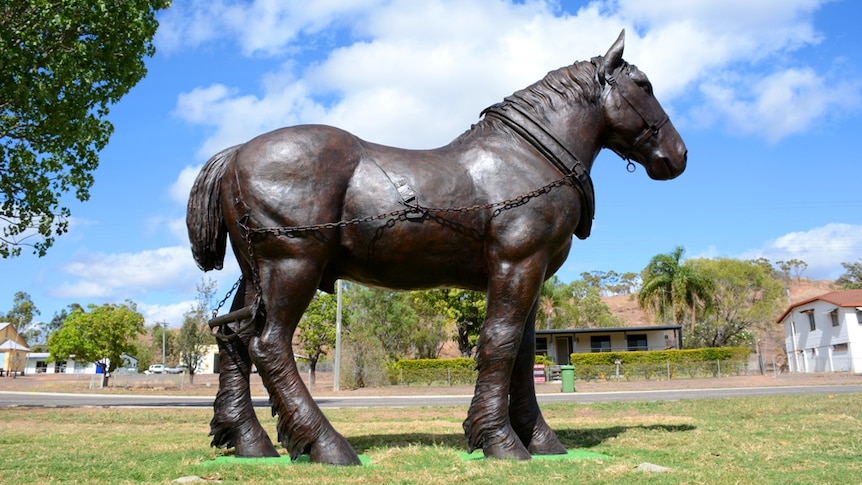 A bronze statue of a horse in a park.