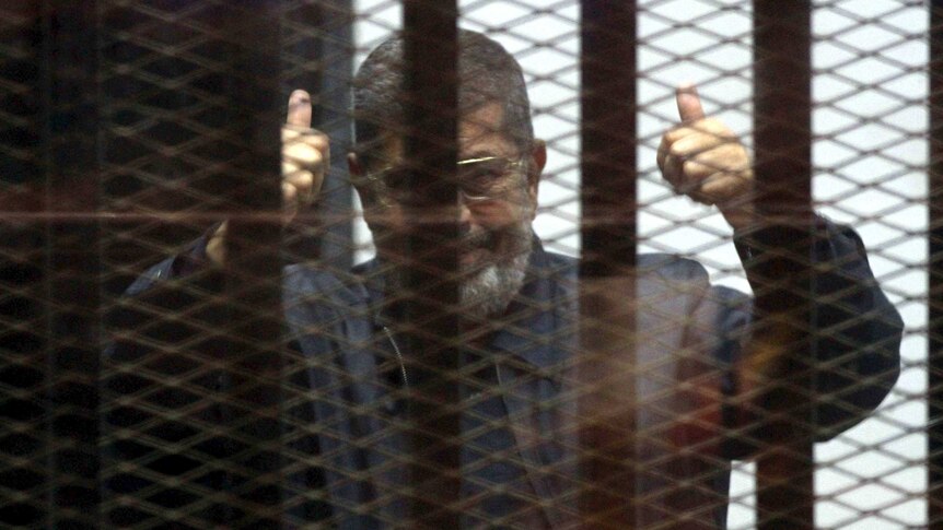 Mohamed Morsi is seen behind bars.