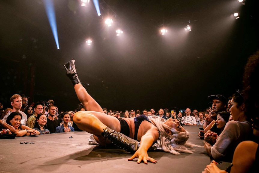 A vogue performer lies on her back, with right leg in the air, on the runway at Sissy Ball 2019.