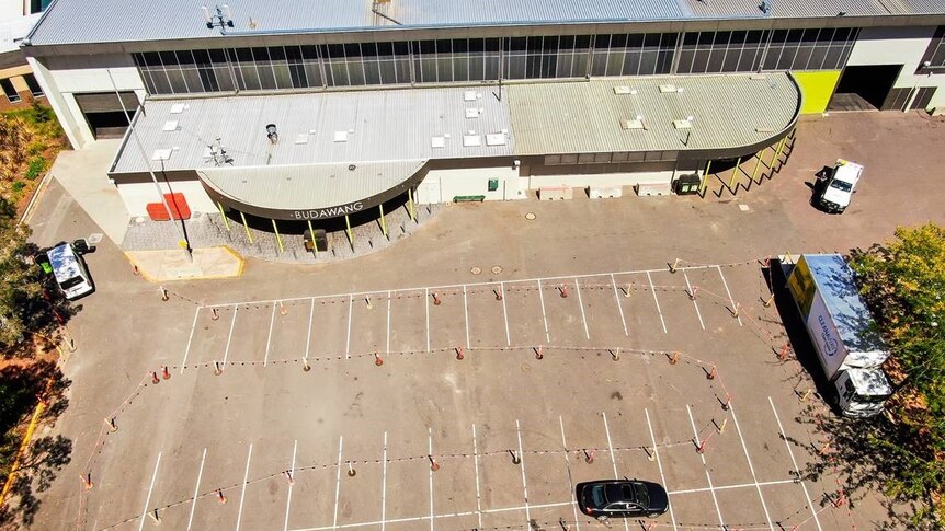 An aerial shot of a car driving through witches hats.