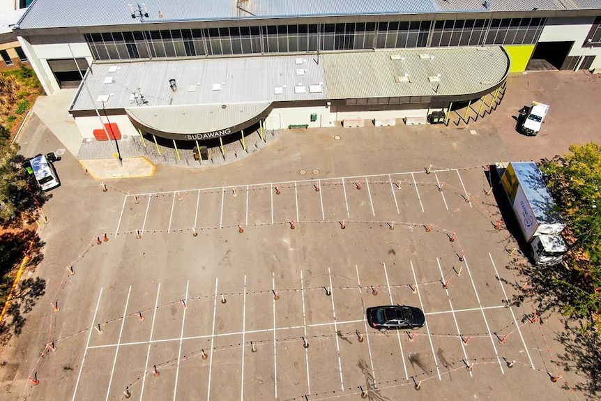 An aerial shot of a car driving through witches hats.