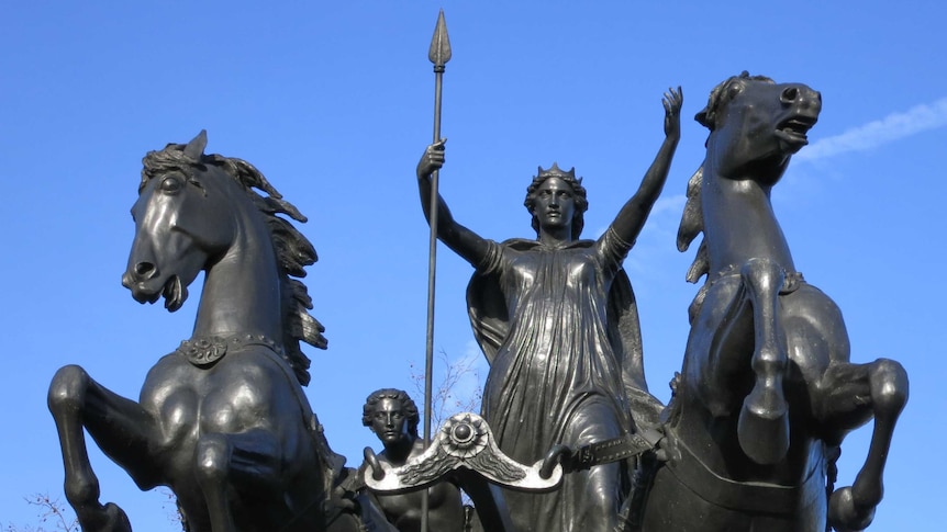 Bronze statue of a woman carrying a spear and riding on a chariot pulled by two horses.