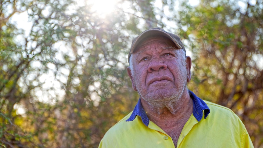 A older aboriginal man looks up.