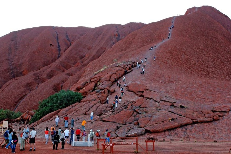People climbing the side of Uluru.