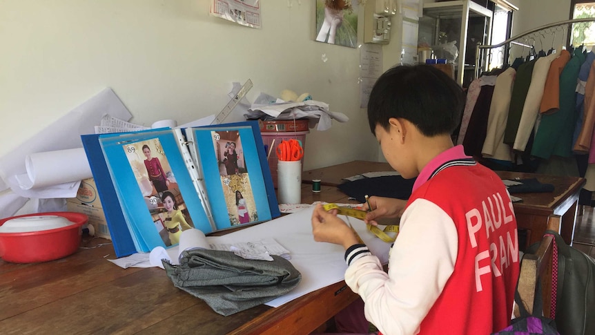 Young girl learning how to sew in Laos