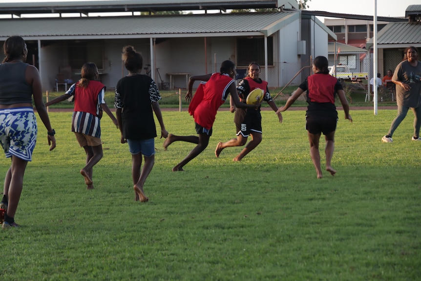 A group playing footy at the Nhulunbuy football oval.