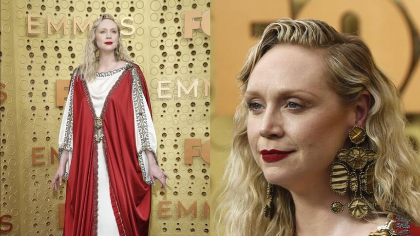 Gwendoline Christie wears a red and white gown and has her blonde hair down as she stands against yellow backdrop.