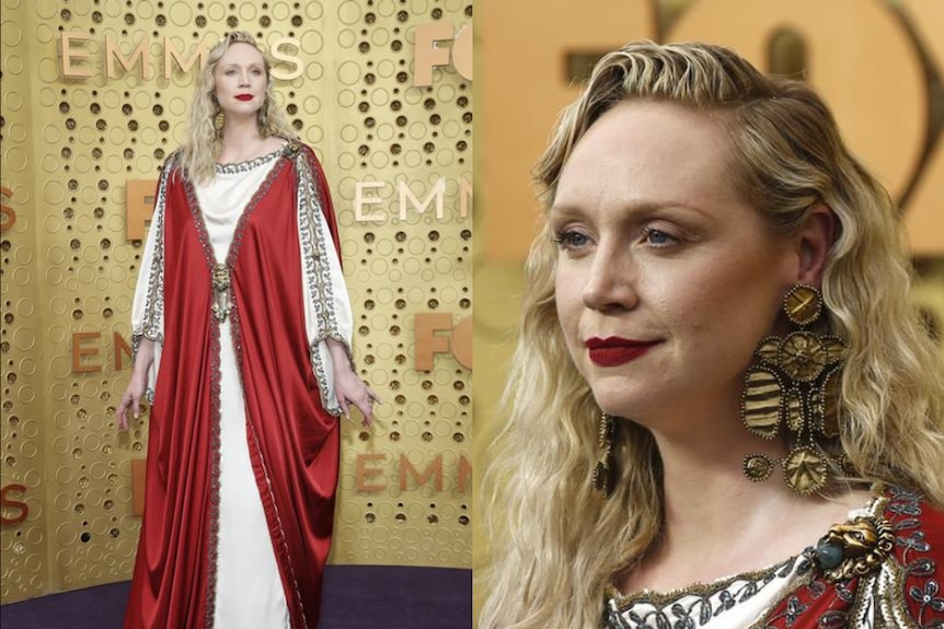 Gwendoline Christie wears a red and white gown and has her blonde hair down as she stands against yellow backdrop.