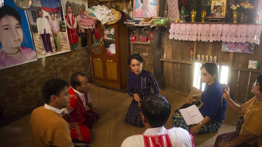 Aung San Suu Kyi (C) meets with residents during her door-to-door visit for voter education campaign in Wartheinkha, outside Yangon